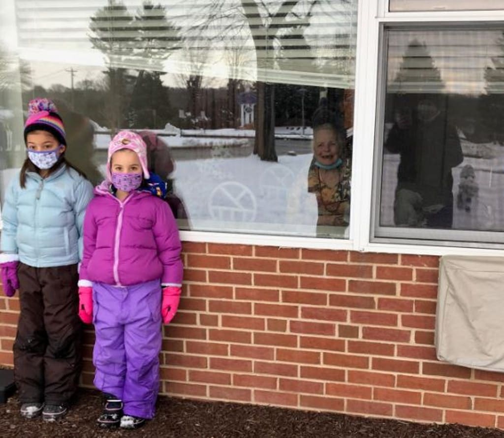 The smile on the resident in the window leaves no doubt they enjoyed watching the kids build snowmen.