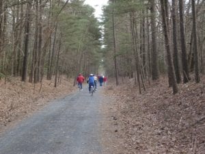 a group of people walking down a dirt road