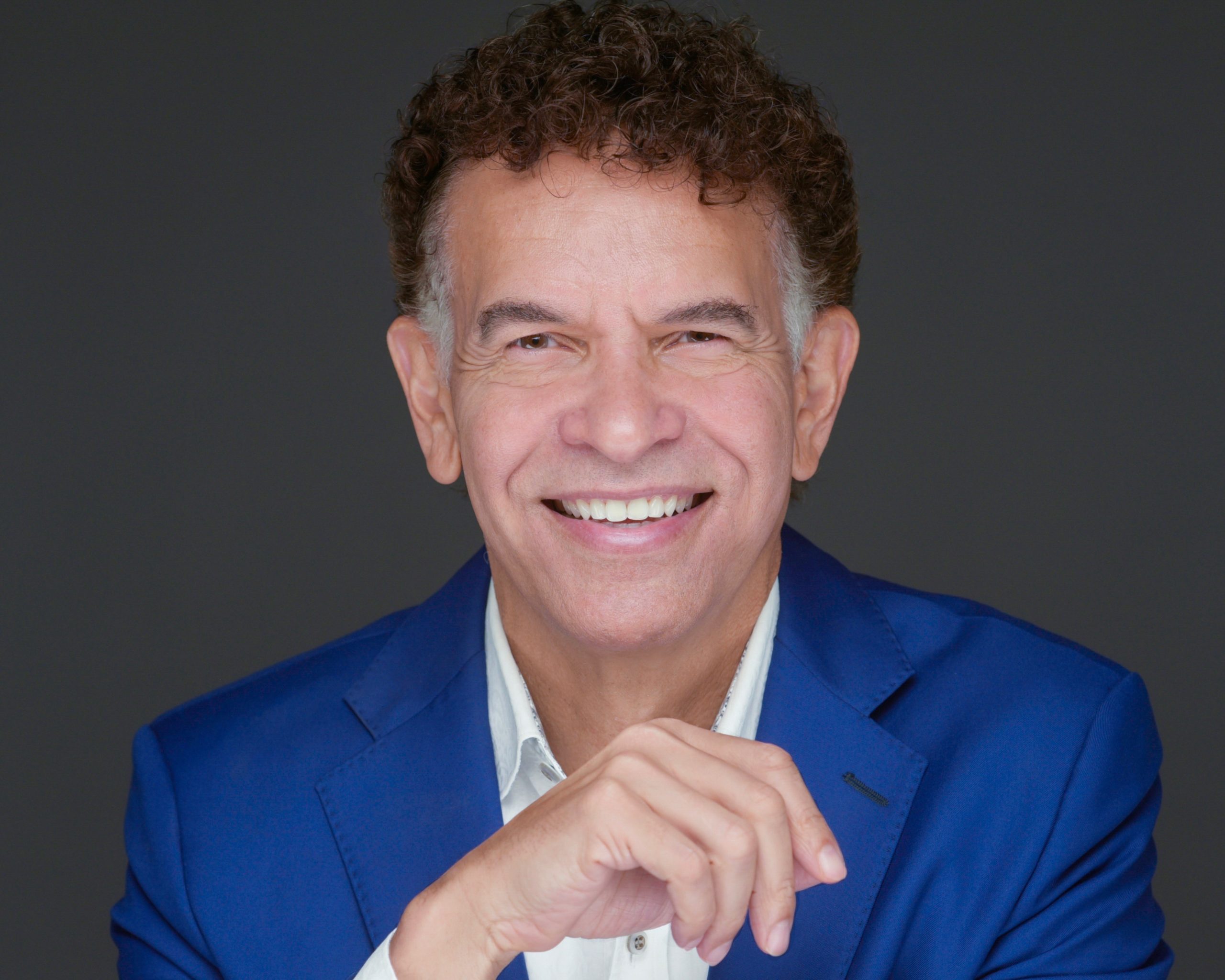 Brian Stokes Mitchell wearing a blue shirt and smiling at the camera