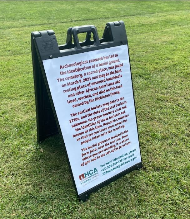 a sign on a grassy field