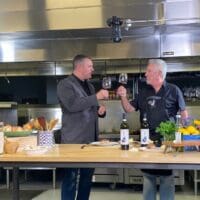 Food Bank Board Member Jeff Whitmarsh and guest chef Paul Cullen toast during filming of Cooking for a Cause.
