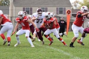Conrad Football player running a ball during a game photo courtesy of Nick Halliday