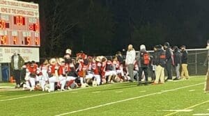 Smyrna football huddles after a big victory near the scoreboard photo courtesy of Smyrna Eagles Max Preps