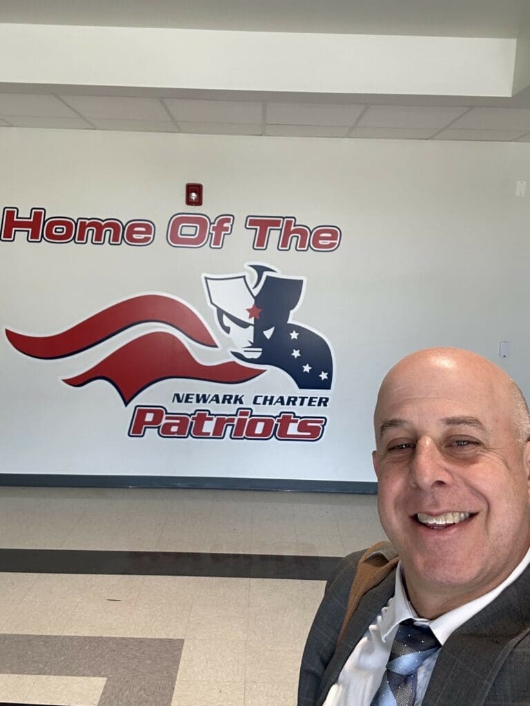 Sam Golder taking a selfie with the Home of the Newark Charter Patriots logo photo courtesy of Sam Golder Head of Newark Charter