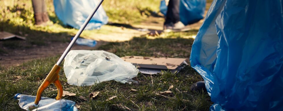 Wilmington Mayor’s office encourages participants in Cleanup Day 3 volunteer using tongs tool collect trash plastic waste from woods scaled e1743103481232
